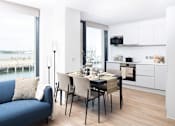 Thumbnail 16 of 25 - A modern kitchen with a dining table set for two.