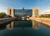 Thumbnail 1 of 32 - a canal with a boat in front of a large building at The Keel Apartments, Liverpool