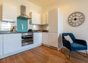 Thumbnail 18 of 32 - a kitchen with a chair and a clock on the wall at The Keel Apartments, Liverpool