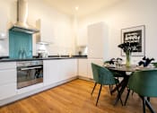 Thumbnail 19 of 32 - a kitchen and dining area with a table and chairs at The Keel Apartments, Liverpool, L3 4GE