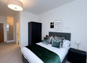 Thumbnail 27 of 32 - a bedroom with a bed and a black and white bedspread and pillows at The Keel Apartments, Liverpool