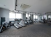 Thumbnail 7 of 30 - spacious gym with floor to ceiling windows and cardio equipment in a building at Vox Apartments, Manchester