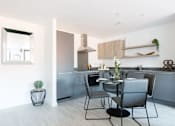 Thumbnail 12 of 30 - a kitchen and dining area with a table and chairs at Vox Apartments, Manchester