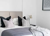Thumbnail 19 of 30 - a bedroom with a bed with black and white pillows at Vox Apartments, Manchester