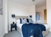 Thumbnail 21 of 30 - a bedroom with a bed and a blue blanket at Vox Apartments, Manchester, M15 4YD