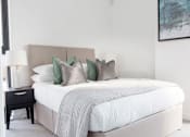 Thumbnail 22 of 30 - a bedroom with a large bed with white sheets and pillows at Vox Apartments, Manchester