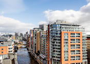 Thumbnail 1 of 24 - A river flows through a city with modern buildings on either side.at Slate Yard Apartments, Salford, M3 5EX