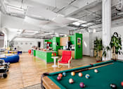 Thumbnail 3 of 4 - A pool table with balls set up for a game in a room with a green wall.