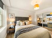 Thumbnail 15 of 24 - A bedroom with a large bed and a window.