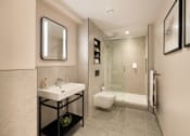 Thumbnail 7 of 24 - A bathroom with a sink, toilet, and shower.