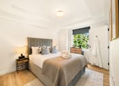 Thumbnail 10 of 24 - A bedroom with a large bed and a window.