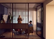 Thumbnail 22 of 24 - Two people are having a conversation in a room with a glass wall.