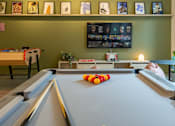 Thumbnail 14 of 27 - a game room with a pool table and a tv