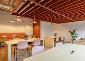 Thumbnail 10 of 27 - a dining area with tables and chairs in a room with orange and white walls