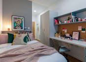 Thumbnail 17 of 27 - a bedroom with a bed and a desk with a work space