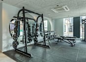 Thumbnail 23 of 27 - a gym with weights and other exercise equipment in the corner of a room