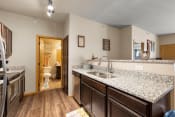 Thumbnail 76 of 126 - a kitchen with granite countertops and dark wood cabinets