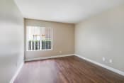 Thumbnail 7 of 33 - an empty living room with wood floors and a window