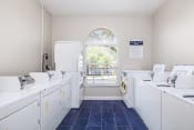 Thumbnail 21 of 24 - a laundry room with white washers and dryers and a window