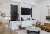 Thumbnail 4 of 35 - a living room with a white brick accent wall and a large flat screen tv on top of