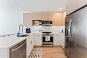 Thumbnail 6 of 54 - a modern kitchen with stainless steel appliances and white counter tops