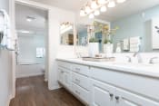 Thumbnail 16 of 28 - a bathroom with white cabinets and a large mirror