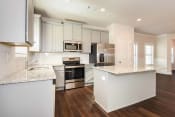 Thumbnail 41 of 61 - an open kitchen with white cabinets and a large island with granite countertops