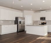 Thumbnail 37 of 61 - a kitchen with white cabinets and a stainless steel refrigerator