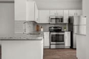 Thumbnail 11 of 40 - a kitchen with white cabinets and stainless steel appliances