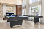 Thumbnail 29 of 40 - two pool tables in a living room with large windows at Aston at Cinco Ranch, Katy, 77450