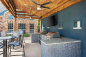 Thumbnail 37 of 40 - a covered patio with a grill and a table with chairs at Aston at Cinco Ranch, Texas