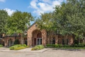 Thumbnail 26 of 40 - the facade of a brick house with an arch and trees at Aston at Cinco Ranch, Katy, 77450
