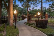 Thumbnail 26 of 28 - a walkway through a park with lamps and a fence at Villages of Cypress Creek, Texas, 77070