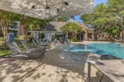 Thumbnail 4 of 16 - a swimming pool with chairs and umbrellas in front of a house at Lakeshore at Preston, Plano, 75093