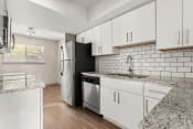 Thumbnail 1 of 24 - a kitchen with white cabinets and a stainless steel refrigerator at South Lamar Village, Texas, 78704