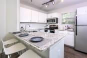 Thumbnail 1 of 17 - a kitchen with white cabinets and a granite counter top at Verdant, Colorado