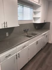 Thumbnail 8 of 12 - a kitchen with white cabinets and a sink