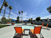 Thumbnail 9 of 33 - a swimming pool with orange chairs and palm trees