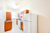Thumbnail 4 of 24 - kitchen with tile flooring, white appliances and oak cabinetry at chatham courts apartments in washington dc