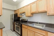 Thumbnail 11 of 36 - kitchen with stainless steel appliances and wood cabinetry at 2800 woodley road apartments in washington dc