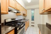 Thumbnail 9 of 36 - kitchen with stainless steel appliances and wood cabinetry at 2800 woodley road apartments in washington dc