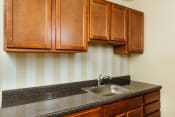 Thumbnail 1 of 17 - kitchen with wood cabinetry and tile backsplash at 2801 pennsylvania apartments in washington dc