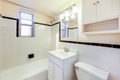 Thumbnail 12 of 22 - bath room with view of toilet, vanity, tub, and window at cambridge square apartments in bethesda md