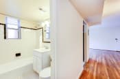 Thumbnail 11 of 22 - bathroom with window, tub, toilet, vanity and view of living area at cambridge square apartments in bethesda md