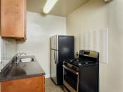Thumbnail 2 of 17 - kitchen with refrigerator, gas range and tile backsplash at 2801 Pennsylvania apartments in washington dc
