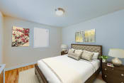 Thumbnail 6 of 16 - bedroom with bed, night stand, hardwood floor and modern lighting at garden village apartments in congress heights washington dc