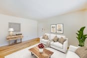 Thumbnail 5 of 16 - a living room with a white couch and a wooden coffee table at garden village apartments in congress heights washington dc