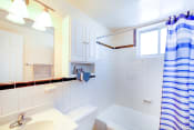 Thumbnail 9 of 16 - bathroom with tub, toilet, mirror, vanity and small windows at garden village apartments in congress heights washington dc