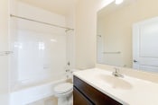 Thumbnail 9 of 16 - bathroom with tub, sink, toilet, and large mirror at sheridan station south townhomes in washington dc