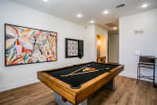Thumbnail 10 of 32 - Octave Apartments  a game room with a pool table and a painting on the wall